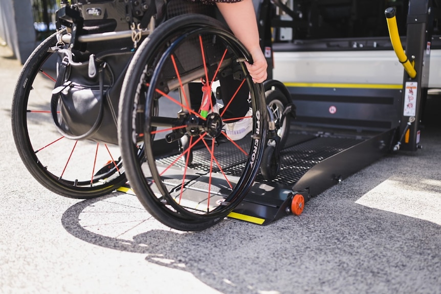 A person waits to enter a wheelchair accessible taxi