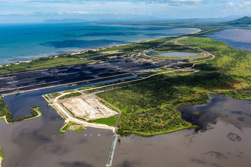 Aerial photo of Abbot Point in north Queensland with coal stockpiles and alleged discoloured water in settlement ponds.