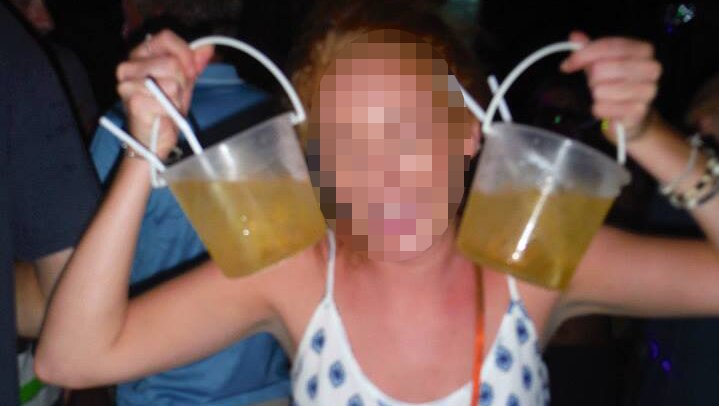 A woman holds up two large beer containers
