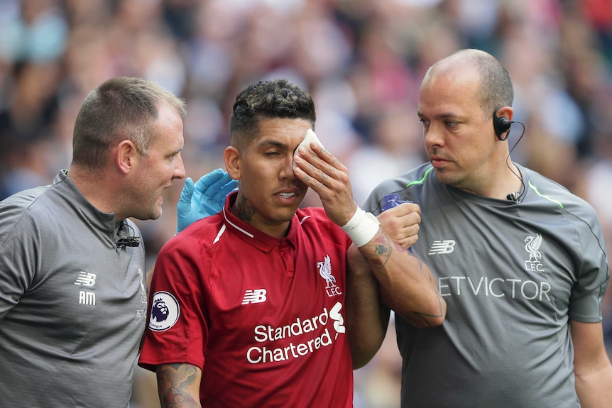 Liverpool's Roberto Firmino, holds patch over his eye after being injured against Spurs at Wembley.