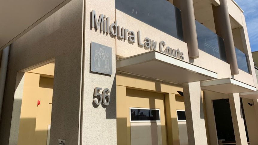 A large, square, sandy coloured building with a sign reading "Mildura Law Courts". The sun is bright.