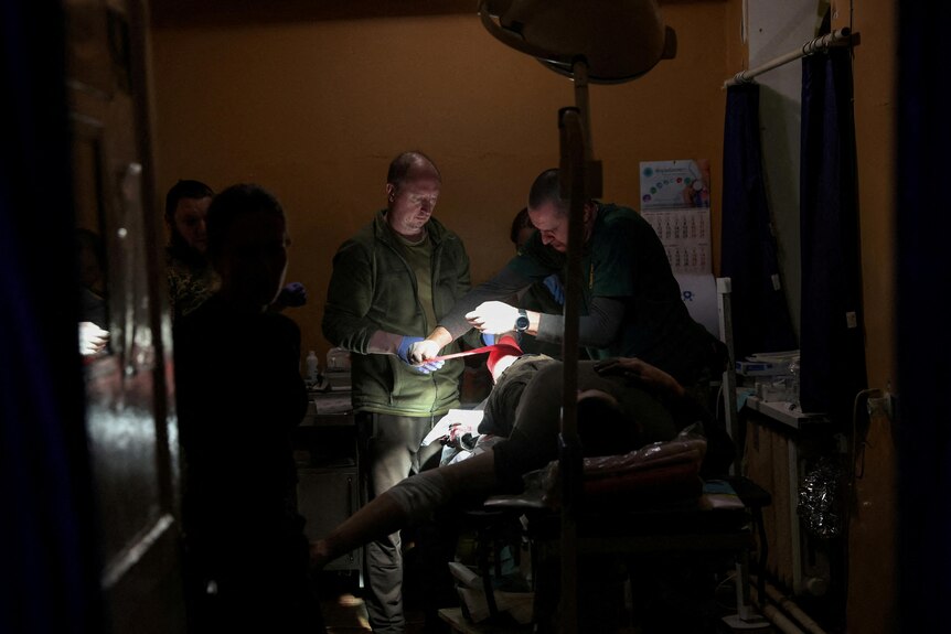 A group of doctors operating on a soldier