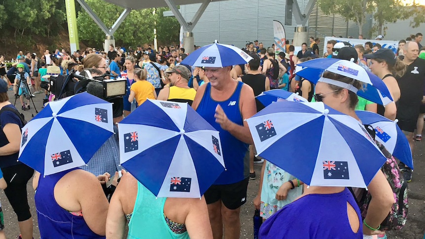 A group of people in Darwin adorn Australia flag hats as they prepare to participate in the annual fun run