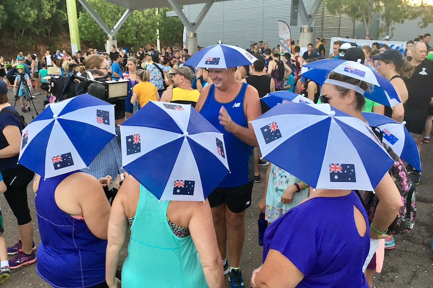 A group of people in Darwin adorn Australia flag hats as they prepare to participate in the annual fun run