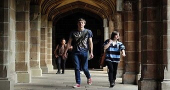 Students walking through a university corridor.