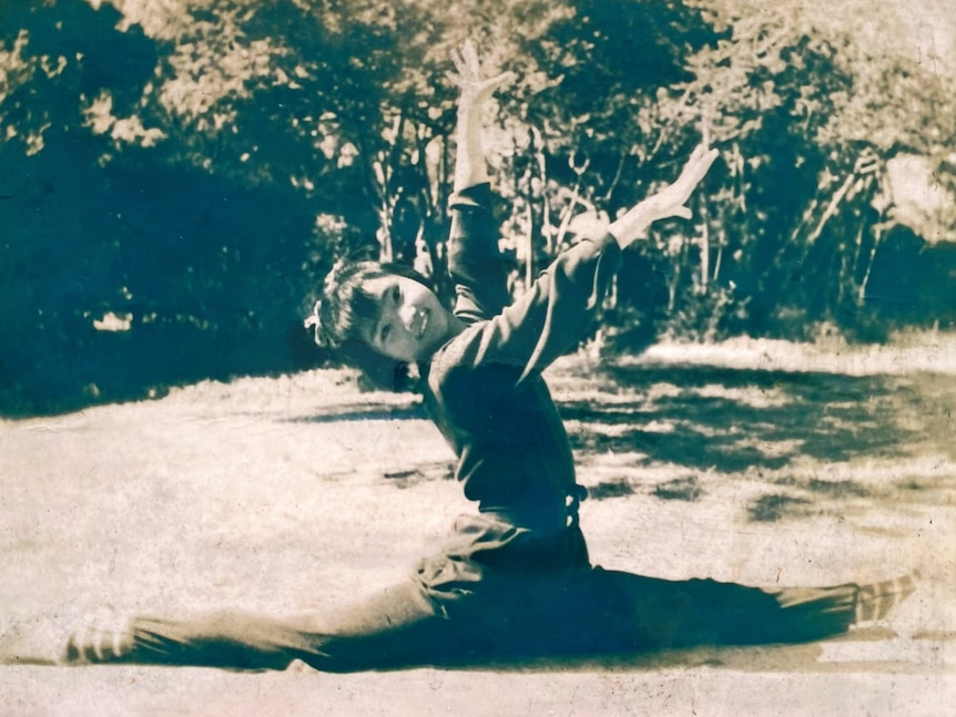 A Chinese kid doing the splits on the grass.