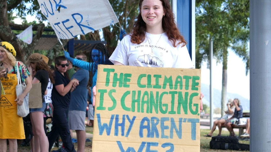 A teenager holding a placard calling for action on climate change
