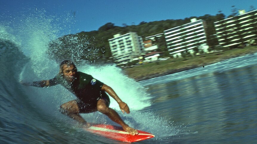 Surfer Peter Drouyn catches a wave at Burleigh Heads, circa 1970s