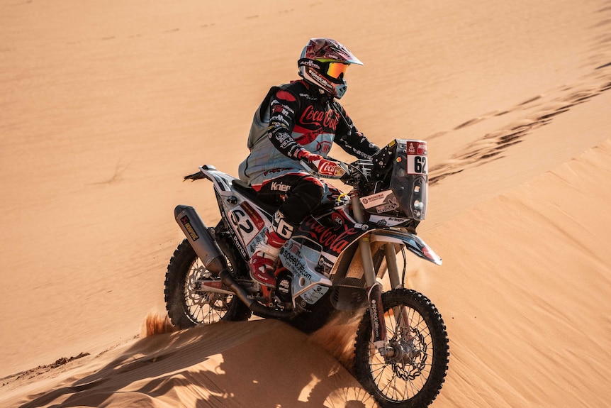 Andrew Houlihan riding motorbike the desert.