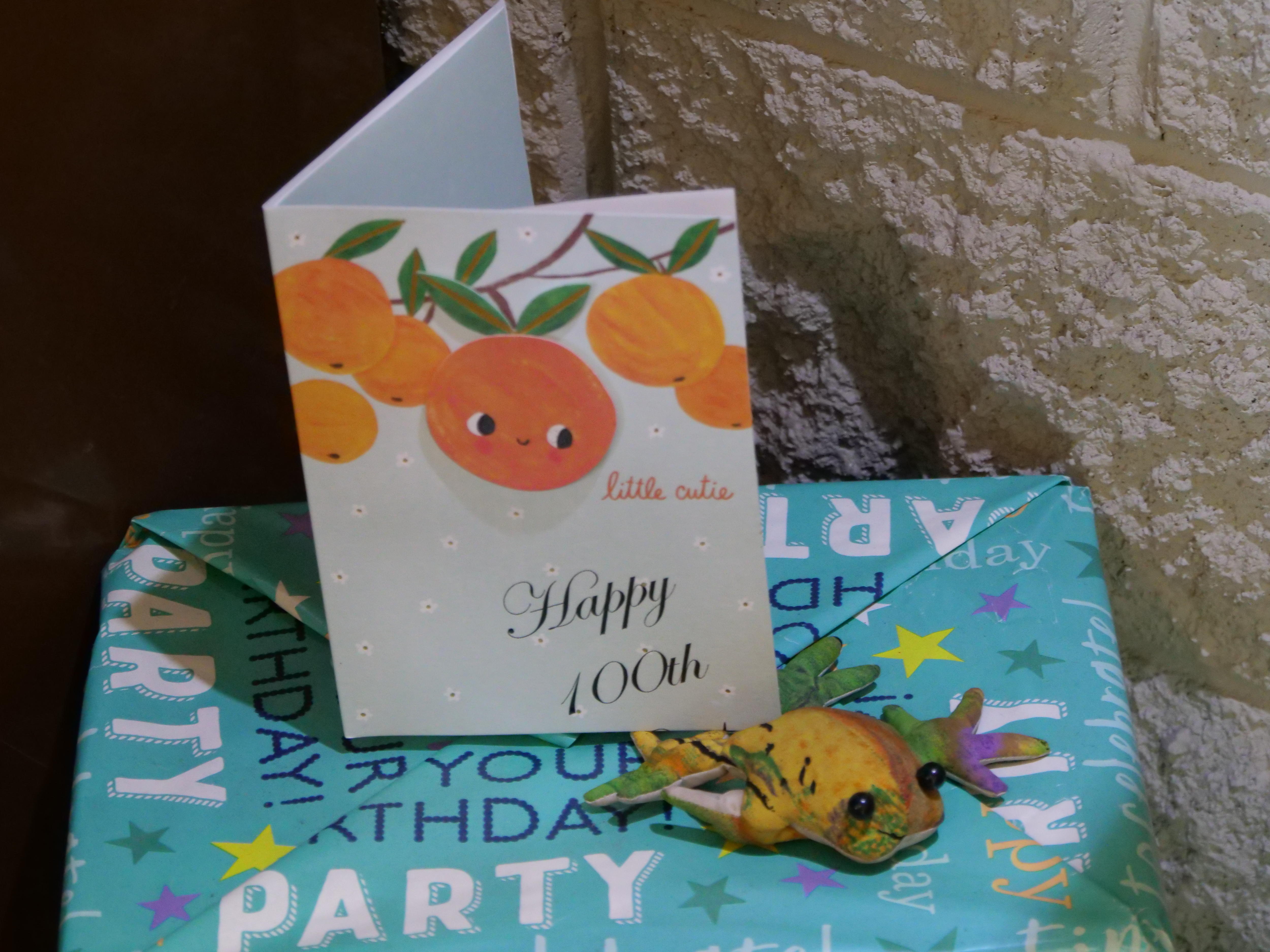 Um cartão de aniversário com laranjas e um presente.