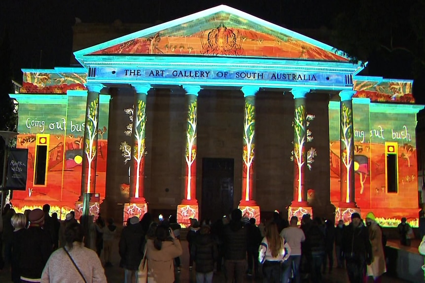 A classical Greek building with lights shining on it