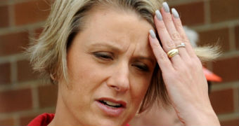 Kristina Keneally frowns, with her hand to her forehead. She looks stressed.