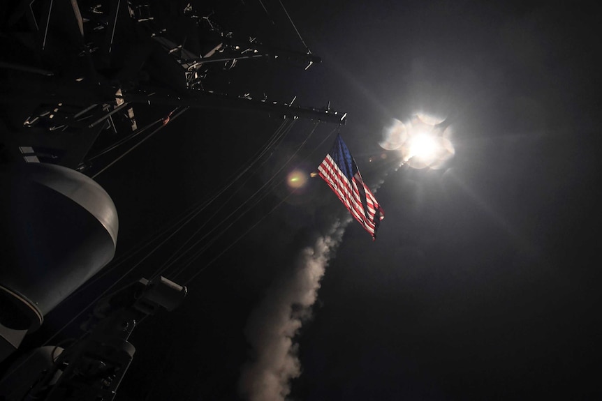 USS Porter launches a tomahawk, the US Flag is visible flying behind it.