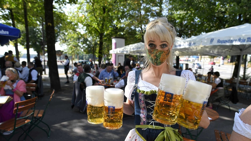 A server carries mugs at a beer garden near Theresienwiese where Oktoberfest would have taken place.