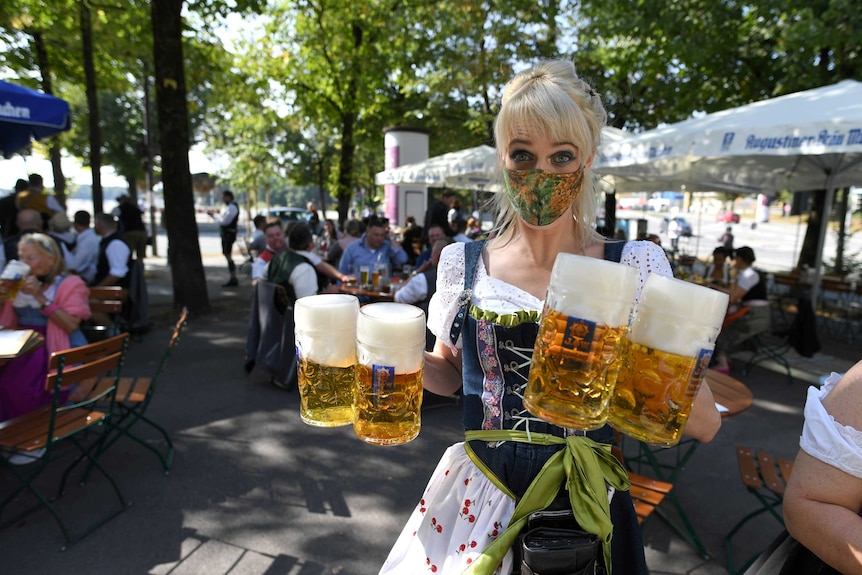 A server carries mugs at a beer garden near Theresienwiese where Oktoberfest would have taken place.