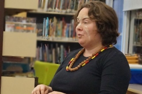 Fleur speaking to a group of school students in a classroom.