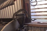 A snake is on a hook being pulled out of a coffee machine.