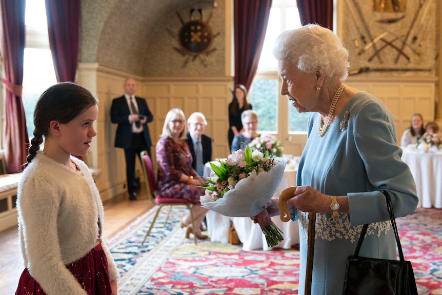 Queen Elizabeth accepts a flower from a little girl at her Platinum Jubilee celebrations, England, February 5, 2022.