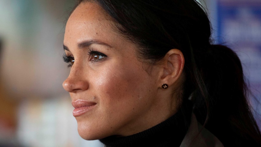 Meghan, the Duchess of Sussex, looks to the left of the image.