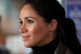 Meghan Markle wearing a dark turtleneck and a poneytail.
