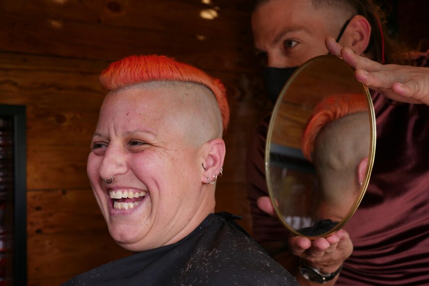 A person smiling after a haircut. 