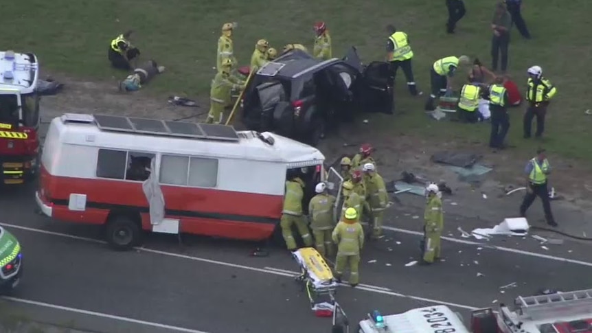 Emergency workers surround the vehicles at the scene of the crash.