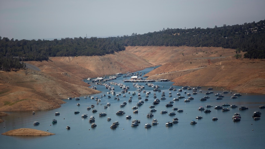 An aerial shot of a lake dotted with boats.