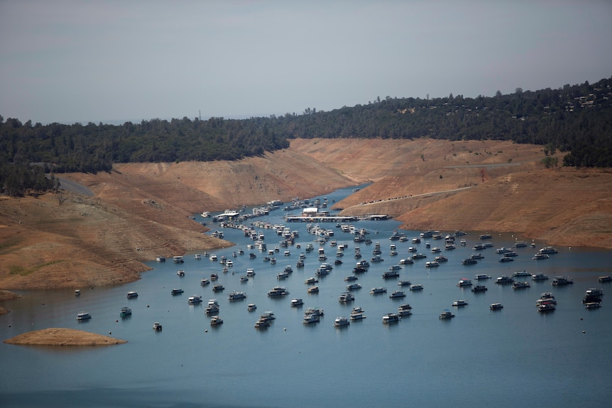 An aerial shot of a lake dotted with boats.