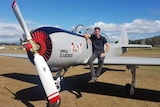 A man sitting on the wing of a small airplane