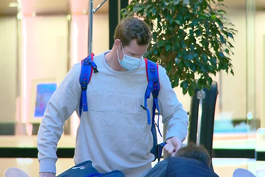 Steve Smith wearing a mask carrying bags