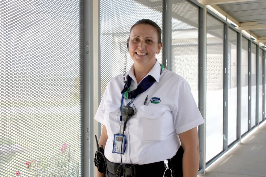 Fulham Correctional Centre officer Vivian Everett stands in a fenced-in corridor.