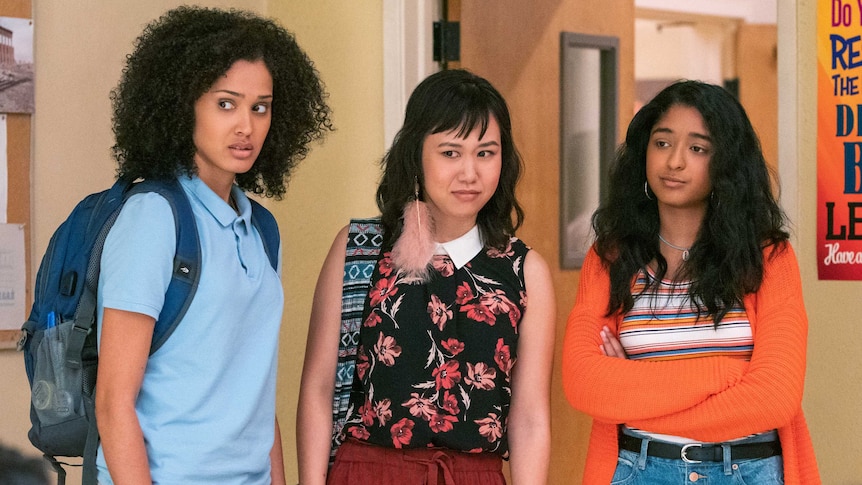 A screengrab of three cast members of Netflix series Never Have I Ever standing in high school.