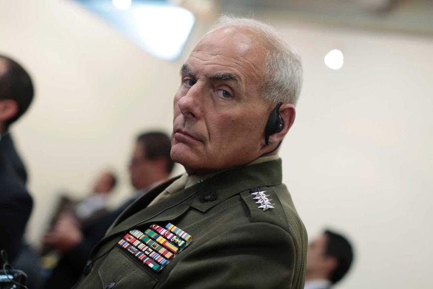 General John Kelly looks towards a photographer