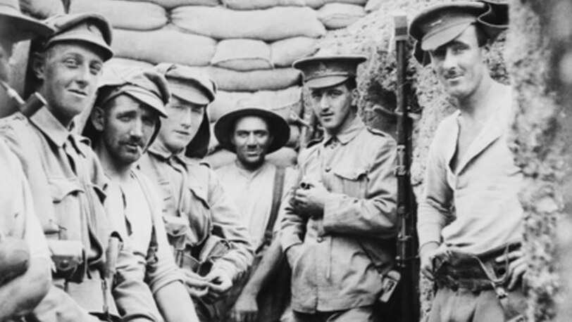 A group of unidentified Australian and New Zealand soldiers in a front line trench on the Gallipoli Peninsula. Several of the men are smoking pipes and cigarettes. Made in 1915.