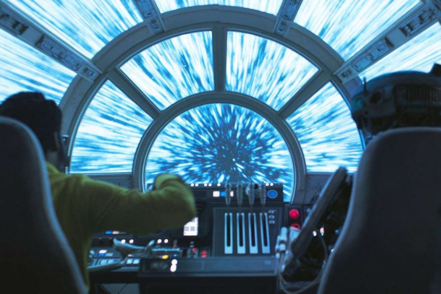 Lando Calrissian and L3-37 face forwards as they travel through hyperspace in a scene from Solo: A Star Wars Story.