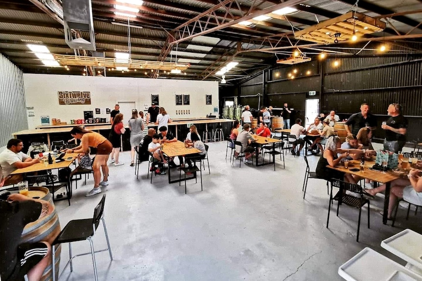 A beer hall with people sitting around tables drinking beer