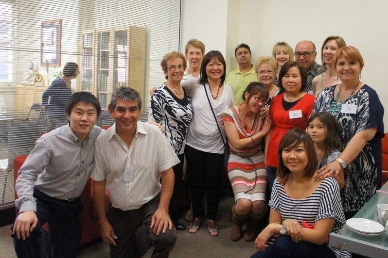 A group of people pose for a photograph in an office.