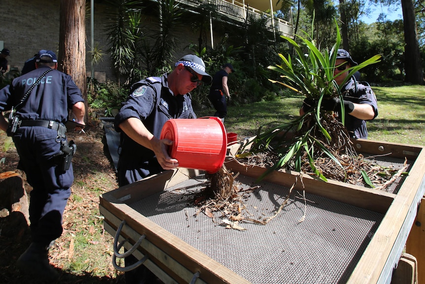 Police officers digging in garden