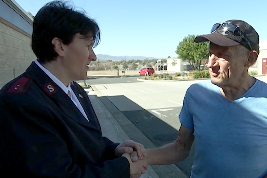 Woman and a man hold hands in thanks.