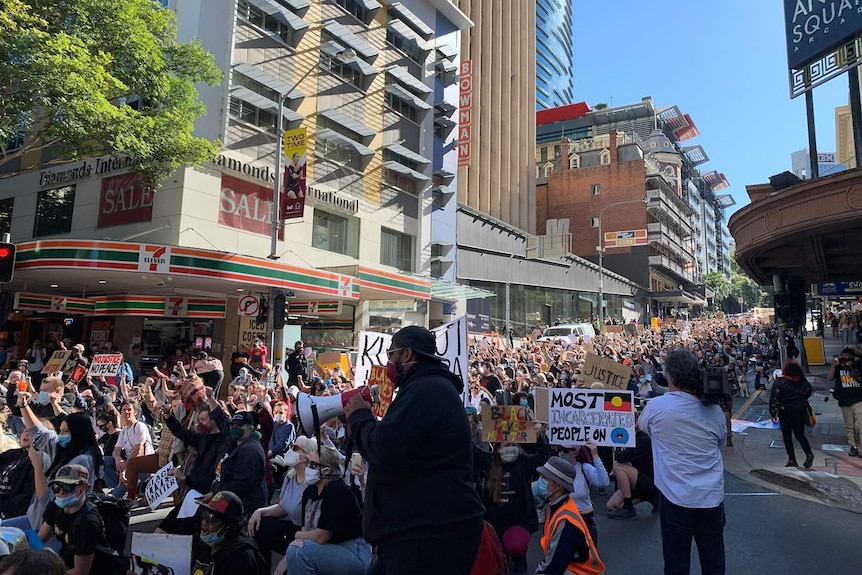 Hundreds of protesters marching through the Brisbane CBD