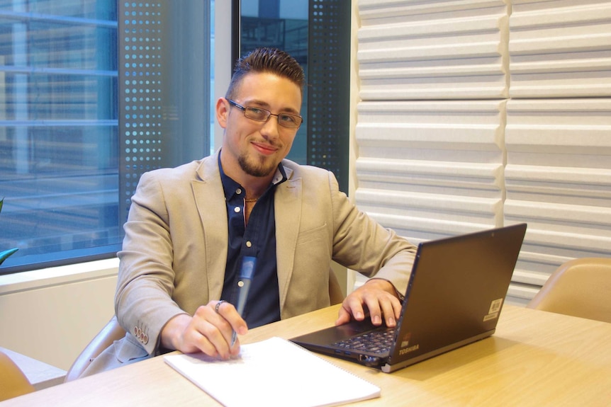 Ben Eisikovich sits in an office behind a laptop