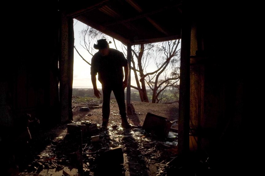 Barry Smith standing inside a room of his damaged property