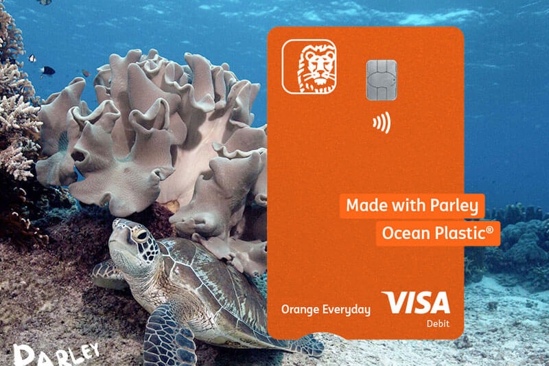 An ad of an orange bank card pictures in front of an ocean background with a coral reef and turtle