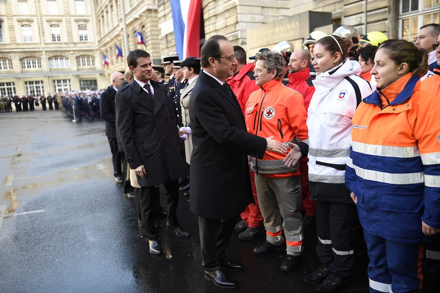 French leaders shake hands with medical staff.