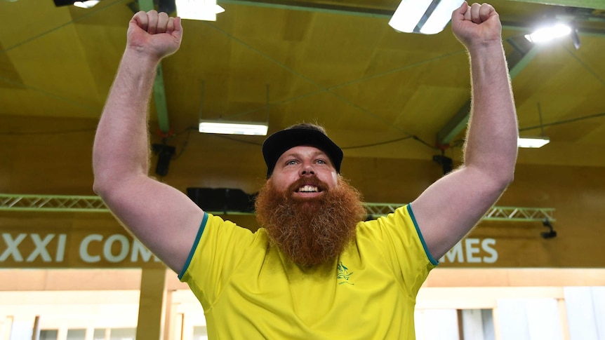 Australian shooter lifts his arm in the air after winning gold at the Commonwealth Games.