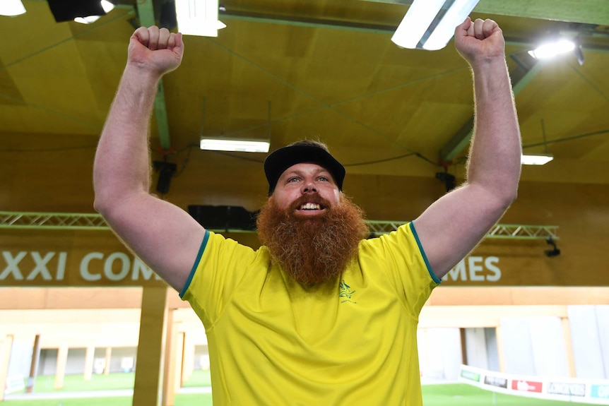 Australian shooter lifts his arm in the air after winning gold at the Commonwealth Games.