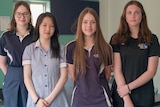 Four female high school students wearing uniforms. 