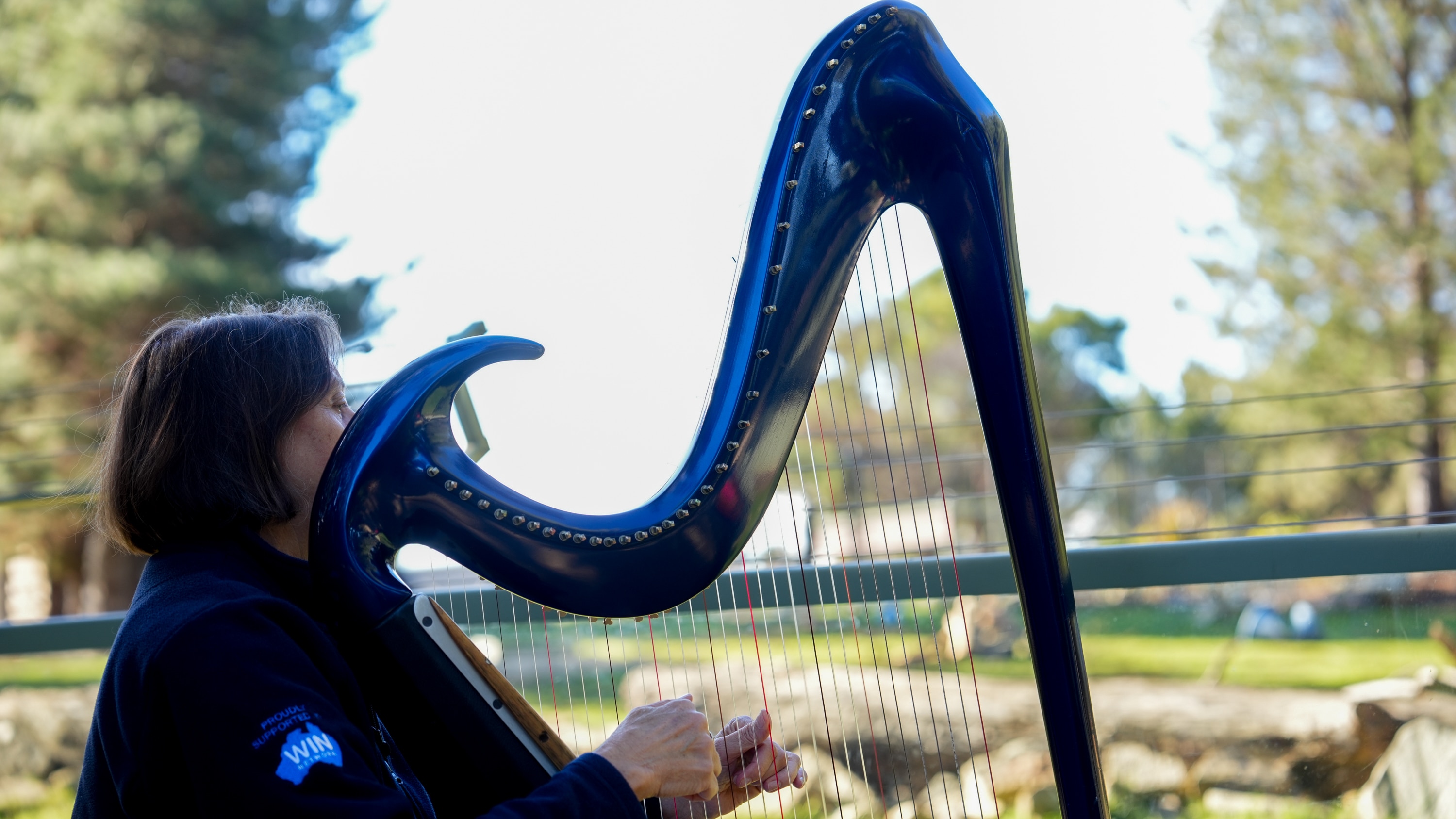 A woman holding a large harp.