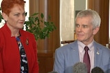 Pauline Hanson stands smiling beside Malcolm Roberts.