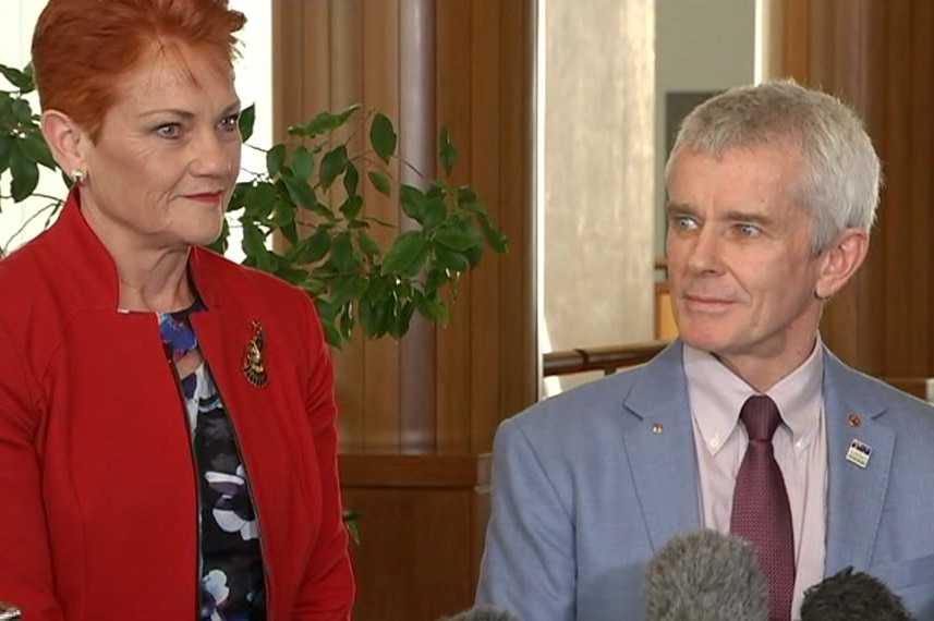 Pauline Hanson stands smiling beside Malcolm Roberts.